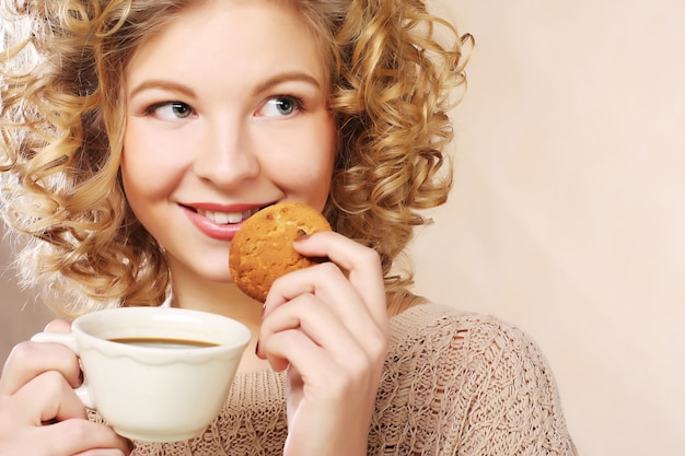 Junge Frau mit Kaffee und Keksen.