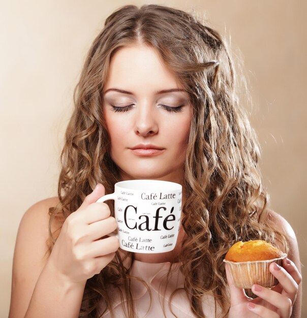 Junge Frau mit Kaffee und Kuchen