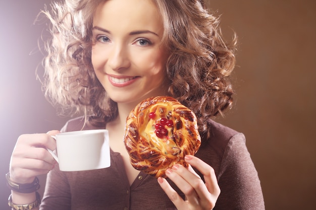 Junge Frau mit Kaffee und Kuchen