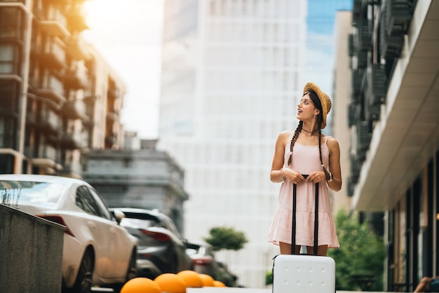 Junge Frau mit Koffer und Blick zur Seite