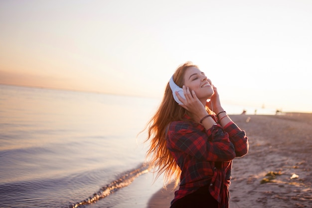 Junge Frau mit Kopfhörern, der Musikliebhaber am Strand