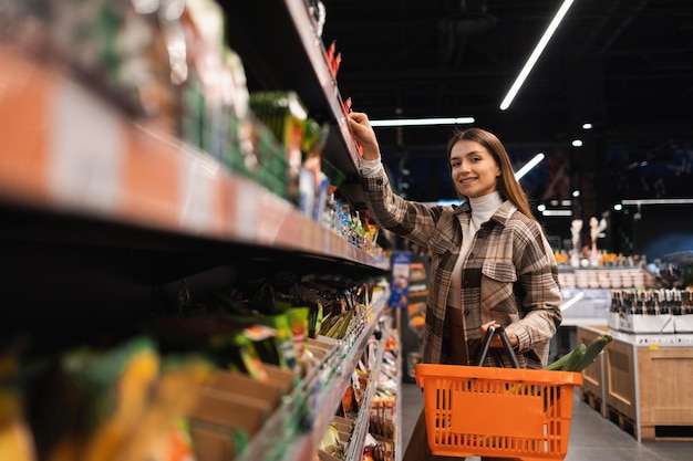 Junge Frau mit Korbeinkauf im Supermarkt