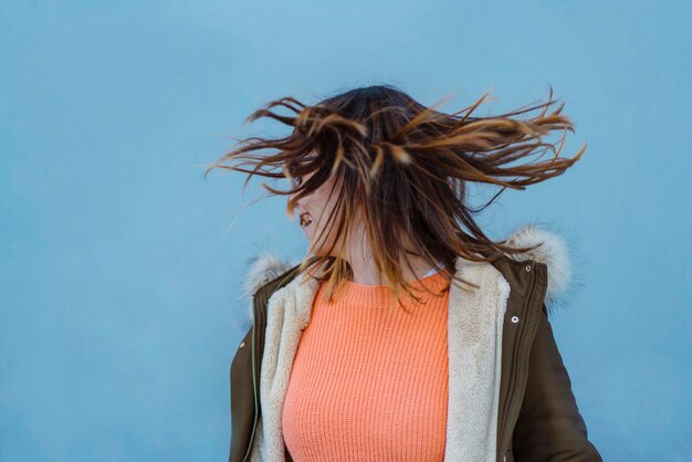 Junge Frau mit kurzen Haaren an der Wand