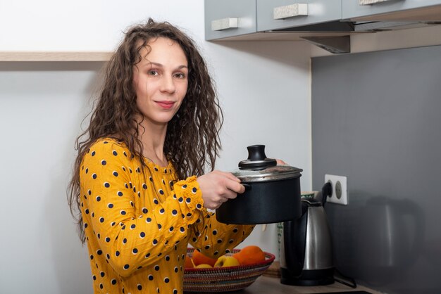 Junge Frau mit langen Haaren ist in der Küche