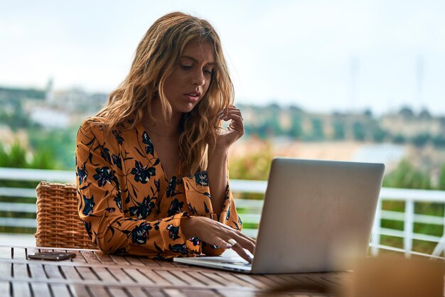 Foto junge frau mit laptop auf dem tisch