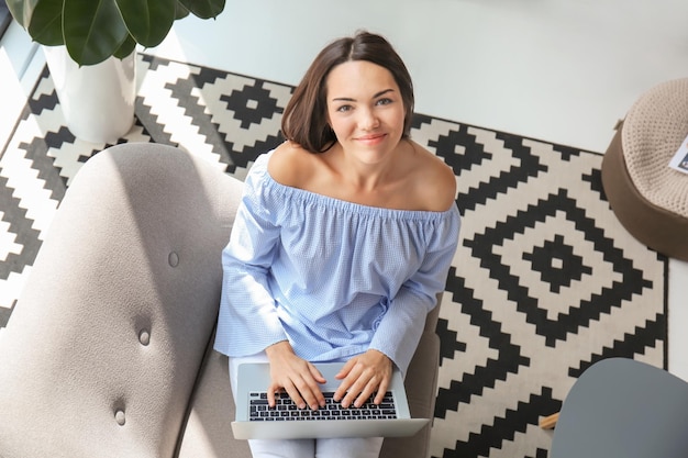 Junge Frau mit Laptop im Wohnzimmer