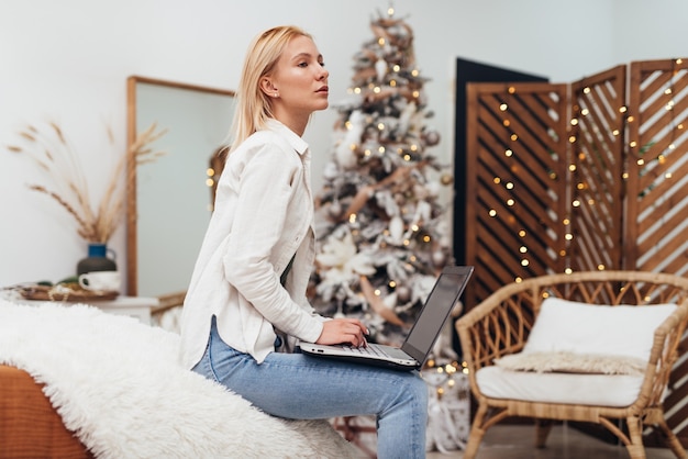 Junge Frau mit Laptop zur Weihnachtszeit