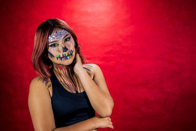 Junge Frau mit Make-up für Halloween-Party-Kostüm-Party-roter Hintergrund