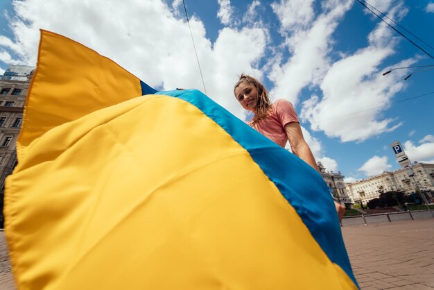 Junge Frau mit Nationalflagge der Ukraine auf der Straße