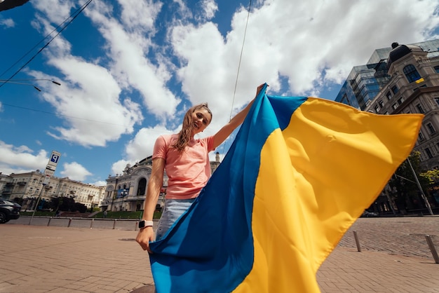 Junge Frau mit Nationalflagge der Ukraine auf der Straße