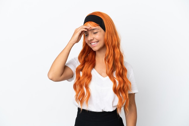 Junge Frau mit orangefarbenen Haaren isoliert auf weißem Hintergrund lächelt viel