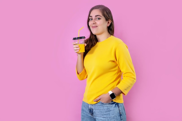 Junge Frau mit Orangensaft auf farbigem Hintergrund