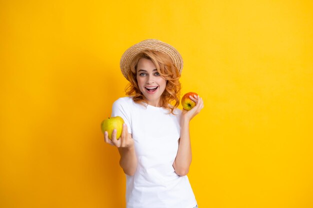 Junge Frau mit Äpfeln lächelnd mit einem glücklichen und coolen Lächeln auf dem Gesicht mit Zähnen Bild einer glücklichen jungen hübschen Frau, die sich isoliert über gelbem Hintergrund mit Apfel ausgibt