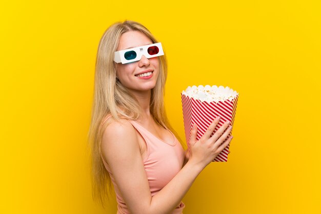 Junge Frau mit Popcorn über rosa Wand