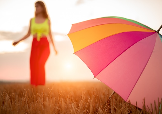 Junge Frau mit Regenschirm im Feld