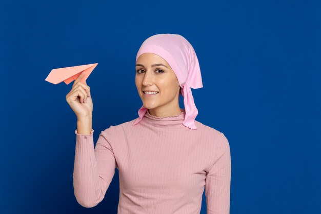 Junge Frau mit rosa Schal auf dem Kopf auf einem Blau