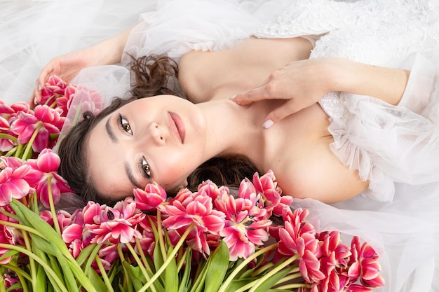 Junge Frau mit rosa Tulpen im weißen Kleid der Hände