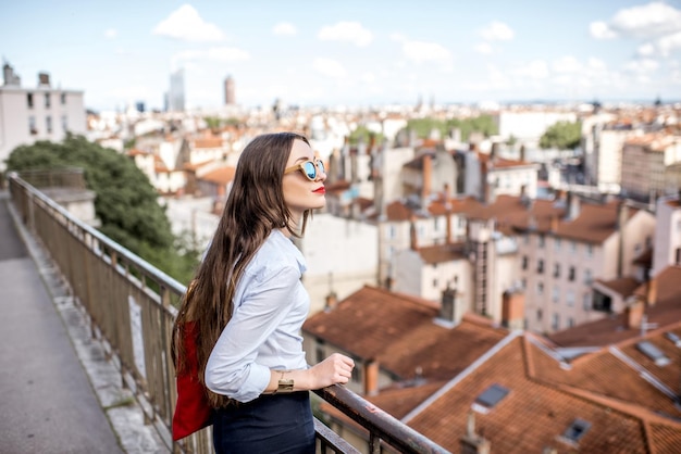 Foto junge frau mit roter tasche mit herrlichem blick auf die stadt lyon in frankreich