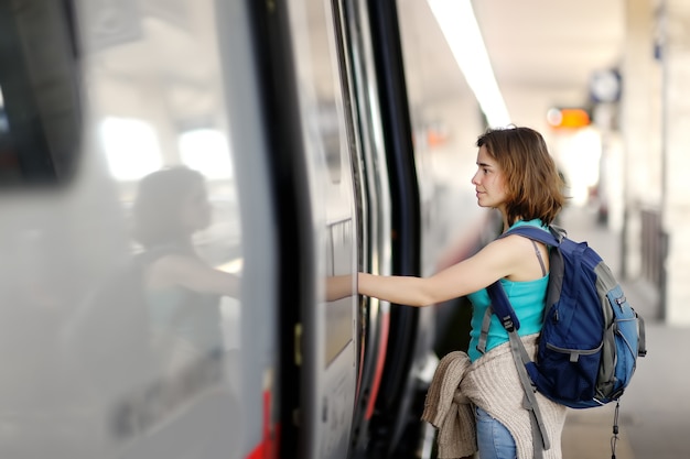 Junge Frau mit Rucksack mit dem Zug.