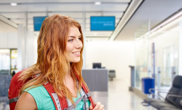 junge Frau mit Rucksack über dem Flughafenterminal