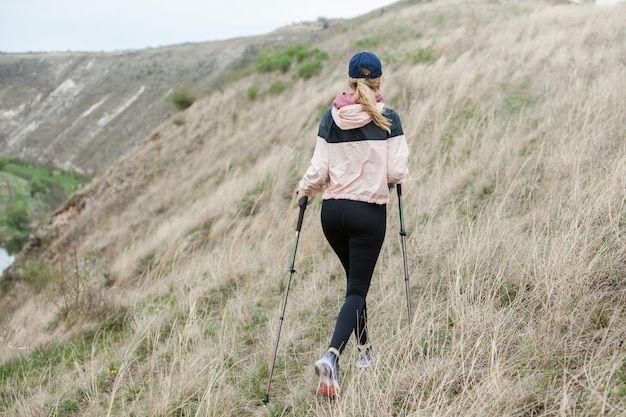 Foto junge frau mit rucksack wandert in den bergen wanderkonzept trekking klippen reisender