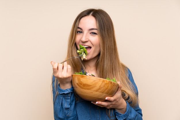 Junge Frau mit Salat über getrenntem Hintergrund