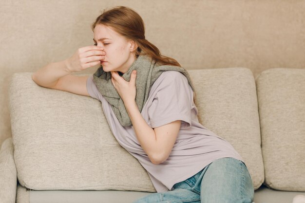 Foto junge frau mit schal hat grippe krank krankheit kälte zu hause drinnen