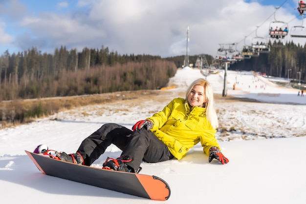 Junge Frau mit Snowboard im Wintersportort