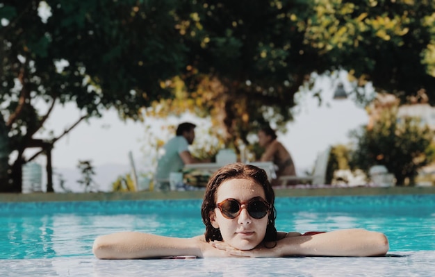 Junge Frau mit Sonnenbrille am Pool