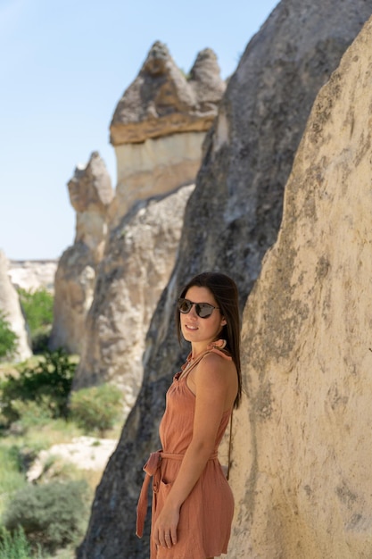 Junge frau mit sonnenbrille, die das pasabag-tal mit typischen felsformationen der kappadokien-region in der türkei besucht