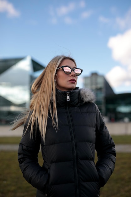 Foto junge frau mit sonnenbrille gegen den himmel