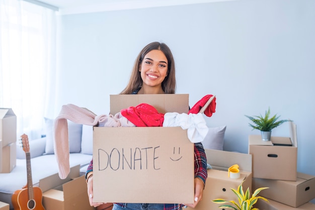 Junge Frau mit Spendenbox zu Hause