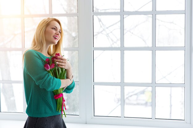 Junge Frau mit Tulpenstrauß, Frühlingsblumen, Sonnenlicht.