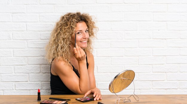 Junge Frau mit vielen Make-upbürste in einer Tabelle