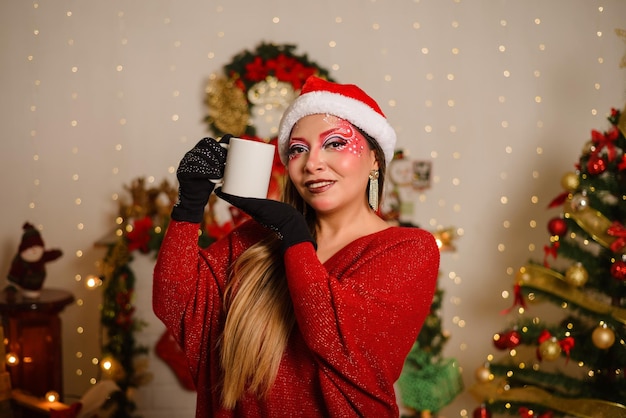 Junge Frau mit Weihnachtsfantasie-Make-up, die weißen Becher hält Selektiver Fokus auf den Becher Weihnachtshintergrund