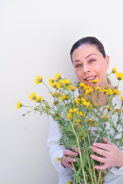 Junge Frau mit Wildblumen auf Weiß