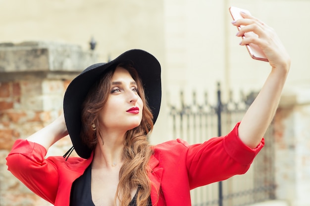 Junge Frau nimmt Selfie im Freien