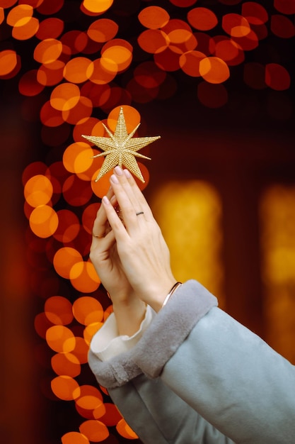 Junge Frau posiert am Weihnachtsbaum an den Winterferien mit Weihnachtsstern.