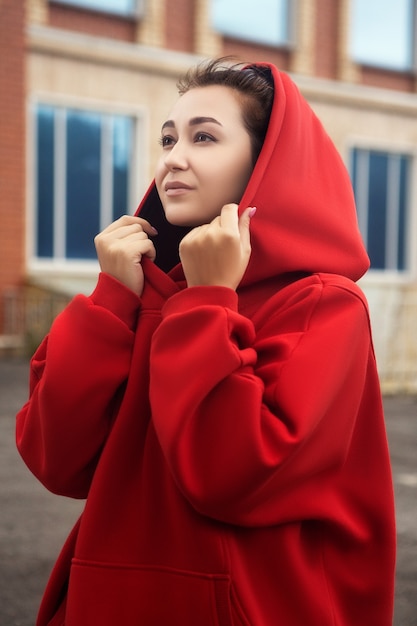 Junge Frau posiert in einem roten, warmen, lässigen Sportkostüm
