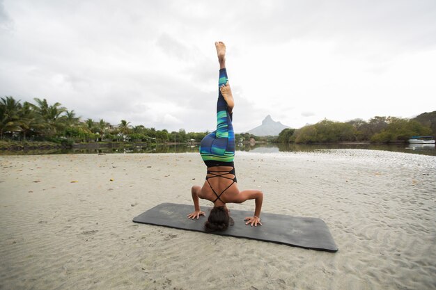 Junge Frau praktiziert Yoga am Ufer des Indischen Ozeans in Mauritius