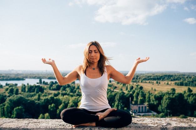 Junge Frau praktiziert Yoga draußen