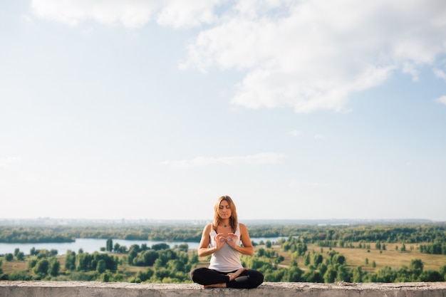 Junge Frau praktiziert Yoga draußen