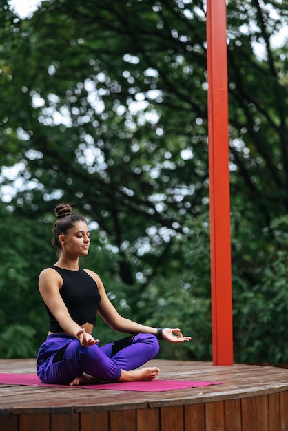 Junge Frau praktiziert Yoga im Lotussitz