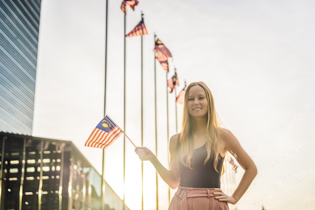 Junge Frau reist in Malaysia Hält die malaysische Flagge