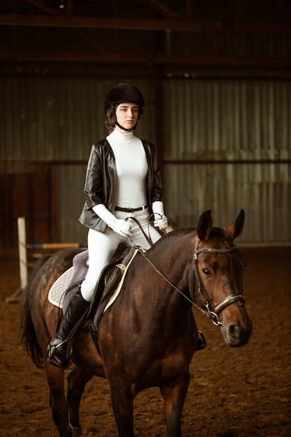Junge Frau Reiterin auf Dressurpferd eine abstrakte Aufnahme von Pferd während des Wettbewerbs süßes Mädchen Jockey Si...