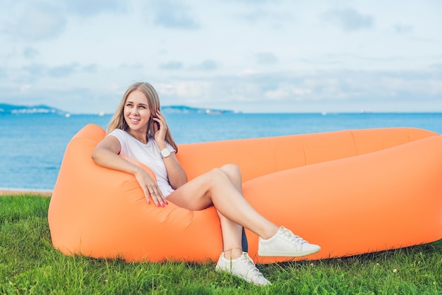 Junge Frau ruht auf einem Luftsofa im Park