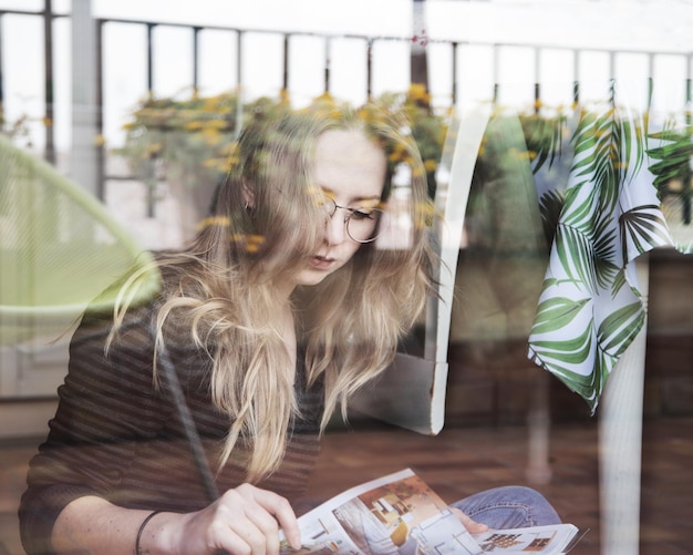 Foto junge frau schaut ab, während sie auf dem tisch sitzt