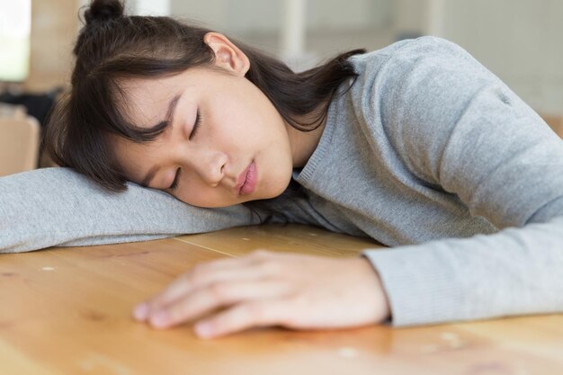 Foto junge frau schläft auf dem tisch