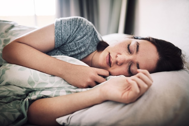 Junge Frau schläft zu Hause im Bett