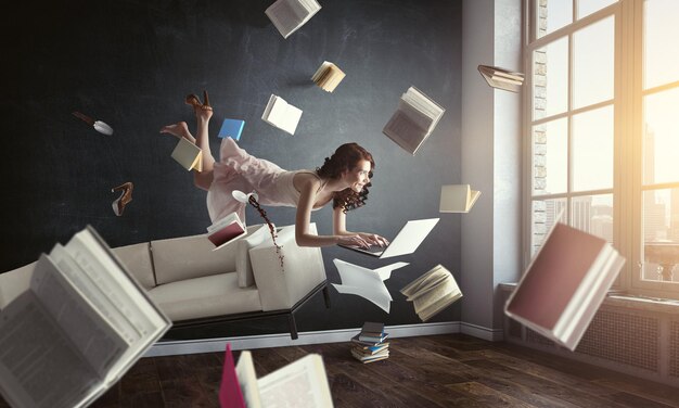 Junge Frau schwebt beim Lesen eines Buches. Gemischte Medien